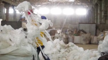 Atık işleme tesisi. Teknolojik süreç. Daha fazla atık için geri dönüşüm ve depolama. Geri dönüşüm fabrikasında plastik bant ütüleyen kadın işçi. Yavaş çekim