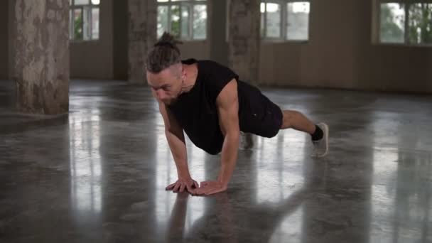 Dorosły muskularny mężczyzna ćwiczący w studio na poddaszu, robiący pompki ręczne. Przystojny model z dredami ćwiczący na poddaszu. Pojęcie dobrego samopoczucia, gimnastyki, aerobiku, zdrowego stylu życia — Wideo stockowe