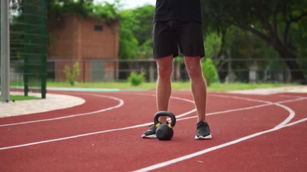 Närbild bilder av en mans ben i svarta sneakers står i främre vikt bob utomhus på banan — Stockvideo