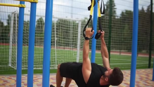 Esportista caucasiano fazendo pull-ups exercício usando cinto de borracha para forçar strenth do treino ao ar livre — Vídeo de Stock