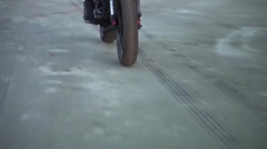 Motosikletli siyah spor bisikletli, kasklı ve farları değişmiş. Rıhtım, gün batımı