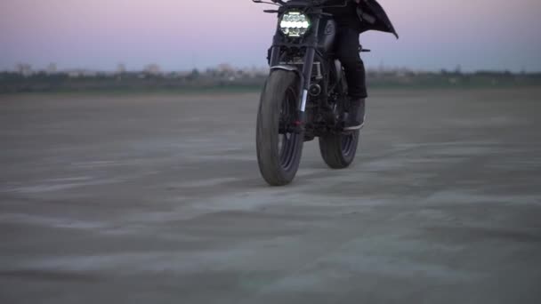 Zbliżenie rowerzystów jeździć na czarnym rowerze sportowym z włączonym przednim światłem przez piaszczysty grunt — Wideo stockowe