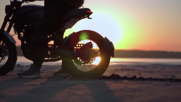 Motocyklista wciska na miejscu z tylnym kołem z zachodem słońca na tle — Wideo stockowe