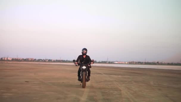 Vista frontal del joven ciclista en casco y chaqueta, el hombre está montando en moto deportiva. Concepto de libertad y aventura — Vídeos de Stock