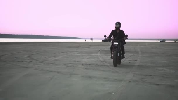 Vista frontal de ciclista irreconocible en casco y chaqueta, el hombre está montando en moto deportiva. Soplado de viento, frente al agua — Vídeos de Stock