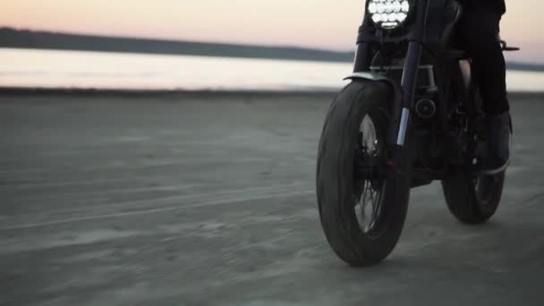 Close up of bikers ride on black sport bike in helmet with switched front headlight. Waterfront, sunset — Stock Video