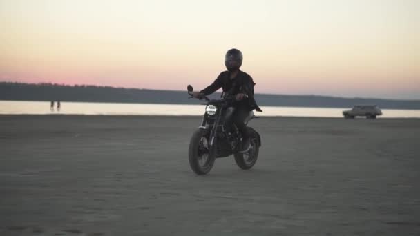 Vista lateral de ciclista irreconocible en casco y chaqueta, el hombre está montando en moto deportiva en la noche, crepúsculo rosa — Vídeos de Stock