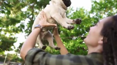 Dehşet saçan kadın mutlu bir şekilde köpeği parkta havaya fırlatıyor.