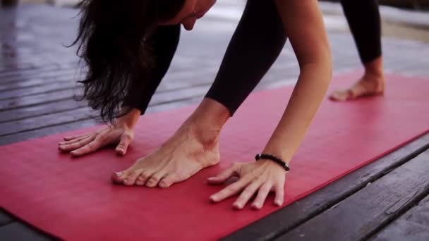 Vue d'ensemble d'une sportive faisant du yoga ou s'étirant sur un tapis à l'extérieur torse penché vers l'avant — Video