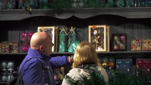 Weihnachtseinkauf. Mann und Frau suchen sich Weihnachtsdekoration im Freiheitshaus aus. — Stockvideo