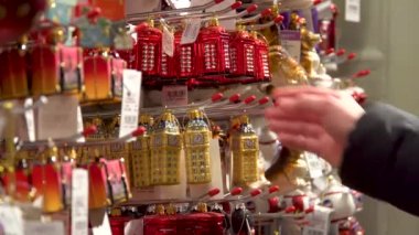 Yakın çekim yukarı vitrin kadın el seçin Noel süslemeleri İngiliz sembolleri büyük ben kırmızı telefon kulübesi. Özgürlük Mağazası. Londra, İngiltere