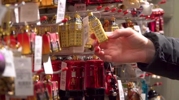 Close-up shot showcase vrouw hand Kies Kerst decoraties Britse symbolen grote ben rode brievenbus. Liberty warenhuis. London, Verenigd Koninkrijk — Stockvideo