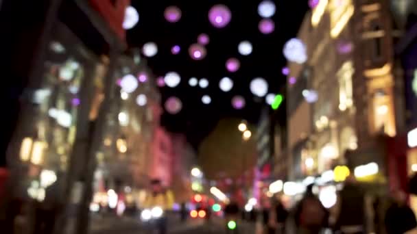 Verschwommene Weihnachtsbeleuchtung, rote Busse und schwarze Taxis auf der belebten Oxford Street. — Stockvideo