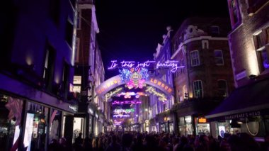 Noel ışıkları, neon sokak aydınlatma, geceleri Carnaby Street downtown Londra şehrinin Soho bölgesinde yürürken insan kalabalığı. Aralık 2018, Londra, İngiltere