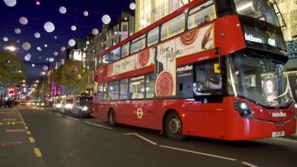 Julbelysning, röda bussar och svart förarhytter på livliga Oxford Street. London, Storbritannien — Stockvideo