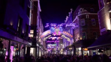 Noel ışıkları, neon sokak aydınlatma, geceleri Carnaby Street downtown Londra şehrinin Soho bölgesinde yürürken insan kalabalığı. Londra, İngiltere