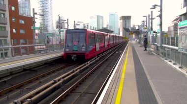 DLR, rıhtım ışık demiryolu banliyö tren istasyondan ayrılıyor. Aralık 2018, Londra, İngiltere