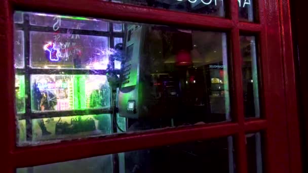 London old scratched red telephone booth night street illumination glass reflecion. — Stock Video