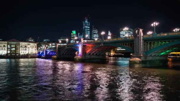 近代的な光の夜やバック グラウンド、ロンドン、英国で街のスカイラインと水の反射で照らされたサザーク橋 — ストック動画