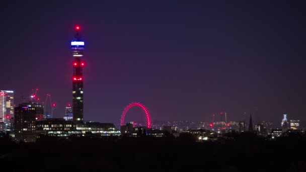 Ночной вид на лондонский небосклон с холма Primrose Hill, показывающий башню BT и лондонский Eye . — стоковое видео