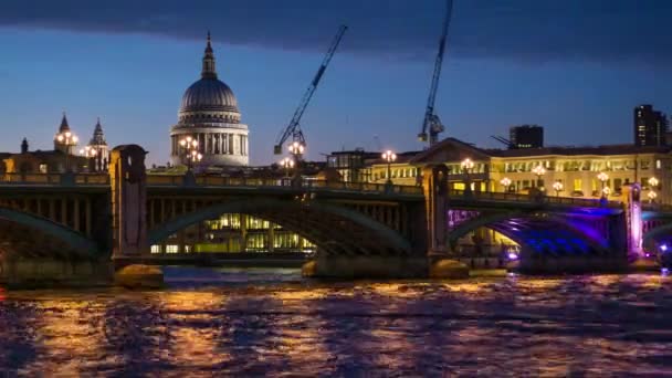 Verlichte Southwark Bridge, St Pauls Cathedral en de rivier de Theems 's nachts in Londen, Engeland — Stockvideo