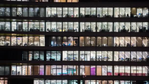 Timelapse en la noche de un moderno edificio de oficinas con ventanas de cristal — Vídeos de Stock