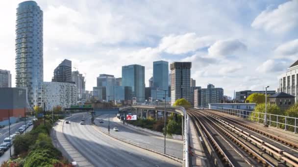 Un train du London Docklands Light Railway quitte la gare de East India. Quartier des affaires de Canary Wharf en arrière-plan . — Video