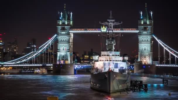 Uitzicht op HMS Belfast, Royal Navy Light Cruiser, oorlogsschip Museum aan de rivier de Theems met de Tower Bridge op de achtergrond 's nachts. Londen, Verenigd Koninkrijk — Stockvideo