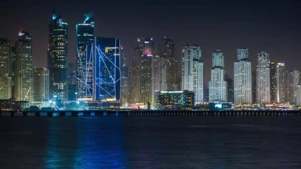 Vistas panorámicas de los rascacielos de Dubai Marina, horizonte nocturno, vista desde Palm Jumeirah, Emiratos Árabes Unidos. El lapso de tiempo. 4K . — Vídeo de stock