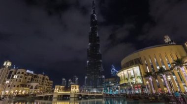 Gece aydınlatması ve Dubai alışveriş merkezi ve Souk Al Bahar yakınında bir köprü ile Burç Halife görünümü. Dubai, Birleşik Arap Emirlikleri. Zaman atlamalı.