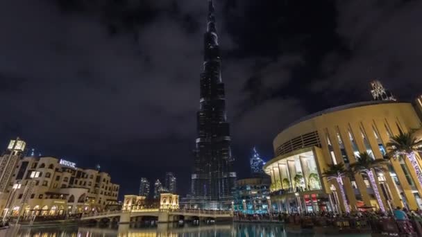 Вид на Бурдж Халифу с ночной подсветкой и мостом рядом с Дубайским молом и Сук Аль Бахар. Дубай, ОАЭ. Временной интервал . — стоковое видео