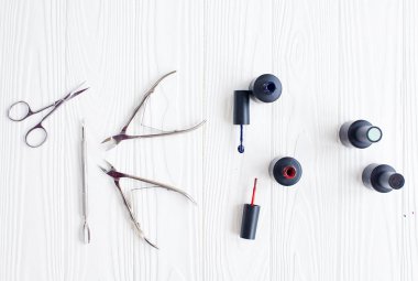 Açık tüp mavi ve kırmızı oje ve beyaz zemin üzerine bir fırça