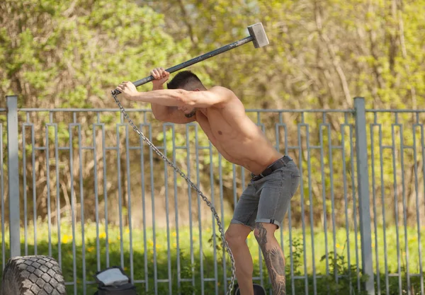 Junger Mann Schlägt Reifen Ein Training Freien Mit Hammer — Stockfoto