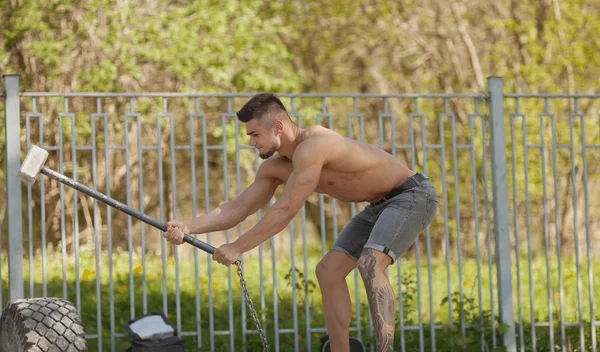 Junger Mann Schlägt Reifen Ein Training Freien Mit Hammer — Stockfoto