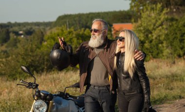 İnsanlar giyen deri kostümleri motosiklet karşı iki yaşlı ve Genç mutlu.