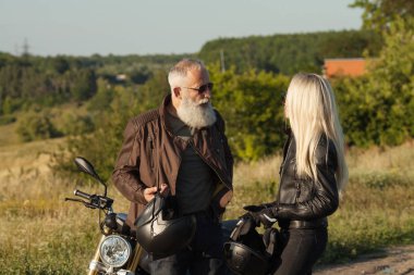 İnsanlar giyen deri kostümleri motosiklet karşı iki yaşlı ve Genç mutlu.