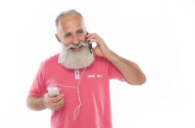 Stüdyo mutlu üst düzey sakallı adam süre şarj ve beyaz arka plan karşı cep telefonu konuşurken gülümseyen bir kadeh. Yaşlı adam şarj telefon. PowerBank.