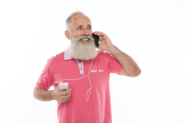 Stüdyo mutlu üst düzey sakallı adam süre şarj ve beyaz arka plan karşı cep telefonu konuşurken gülümseyen bir kadeh. Yaşlı adam şarj telefon. PowerBank.