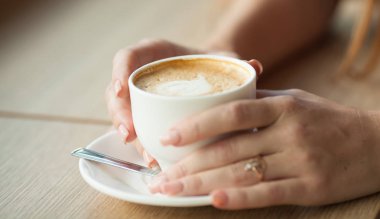 Ahşap masada bir fincan kahve.