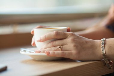 Ahşap masada bir fincan kahve.