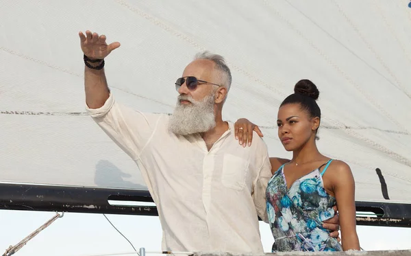 Happy elderly senior with african woman travel on yacht.