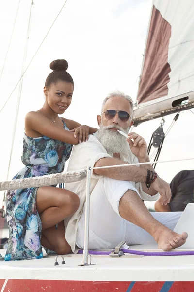 Happy elderly senior with african woman travel on yacht.