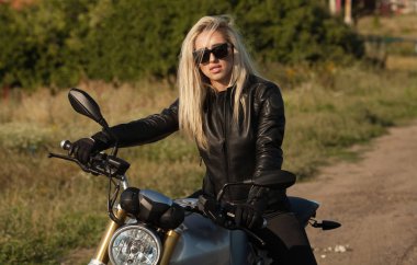 Motorcu kız bir deri ceket ve bir motosiklet kask
