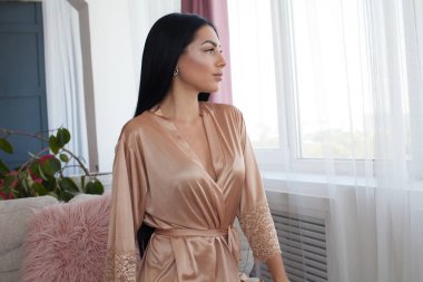 Güzel seksi kadın giyim ipek pijama stil casual kız yürüyüş iç oda toplantı koyu saç moda kataloğu Bayan mükemmel yüz kozmetik ve vücut makyaj ile.