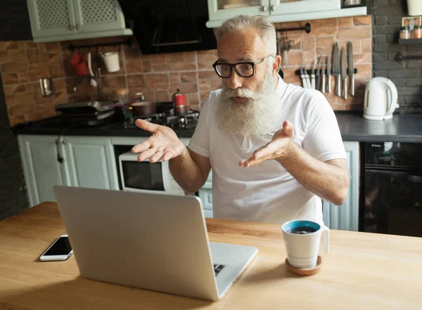 mature bearded man with laptop and eyeglasses