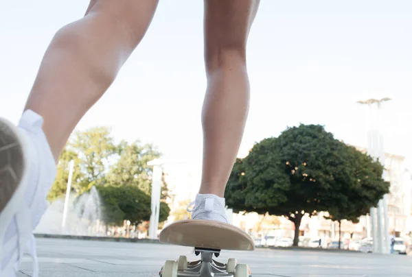 在街道上的木制滑板上的性感女人的腿 — 图库照片