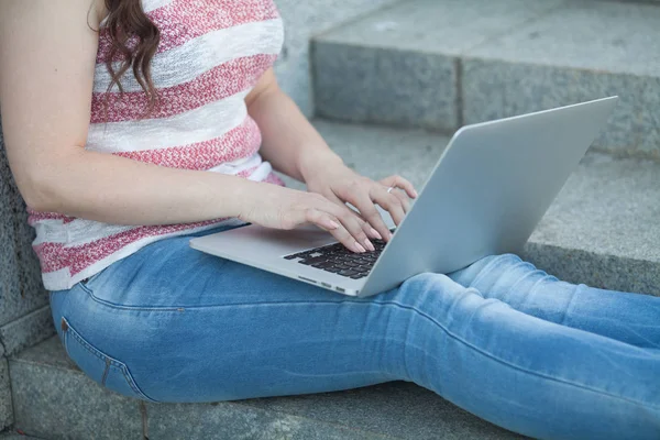 街の階段の上に座って ノート パソコンを屋外で使う幸せな若い女性の肖像画 — ストック写真