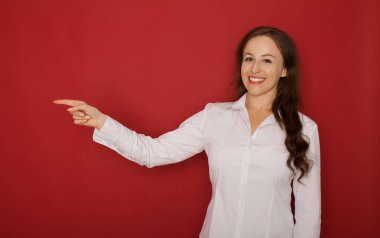 Portre hayran bir genç kadının parmakları uzakta boşaltmak izole kırmızı arka plan üzerinde işaret.