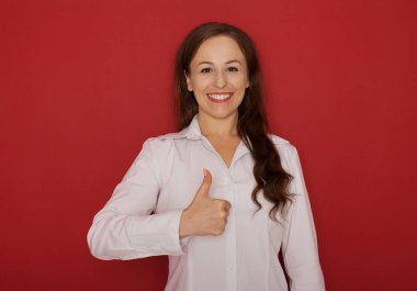 Kırmızı bir arka plan üzerinde izole kadın gösteren başparmak gülümseyen