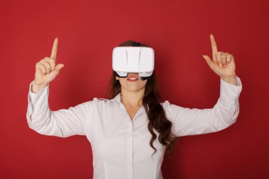 Sanal gerçeklik (Vr) gözlüklü genç kadın. Kırmızı zemin üzerine izole